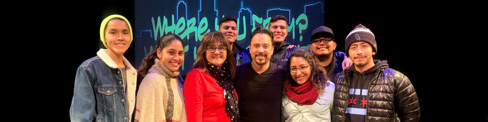 Students take a group photo with a Latin-American performer