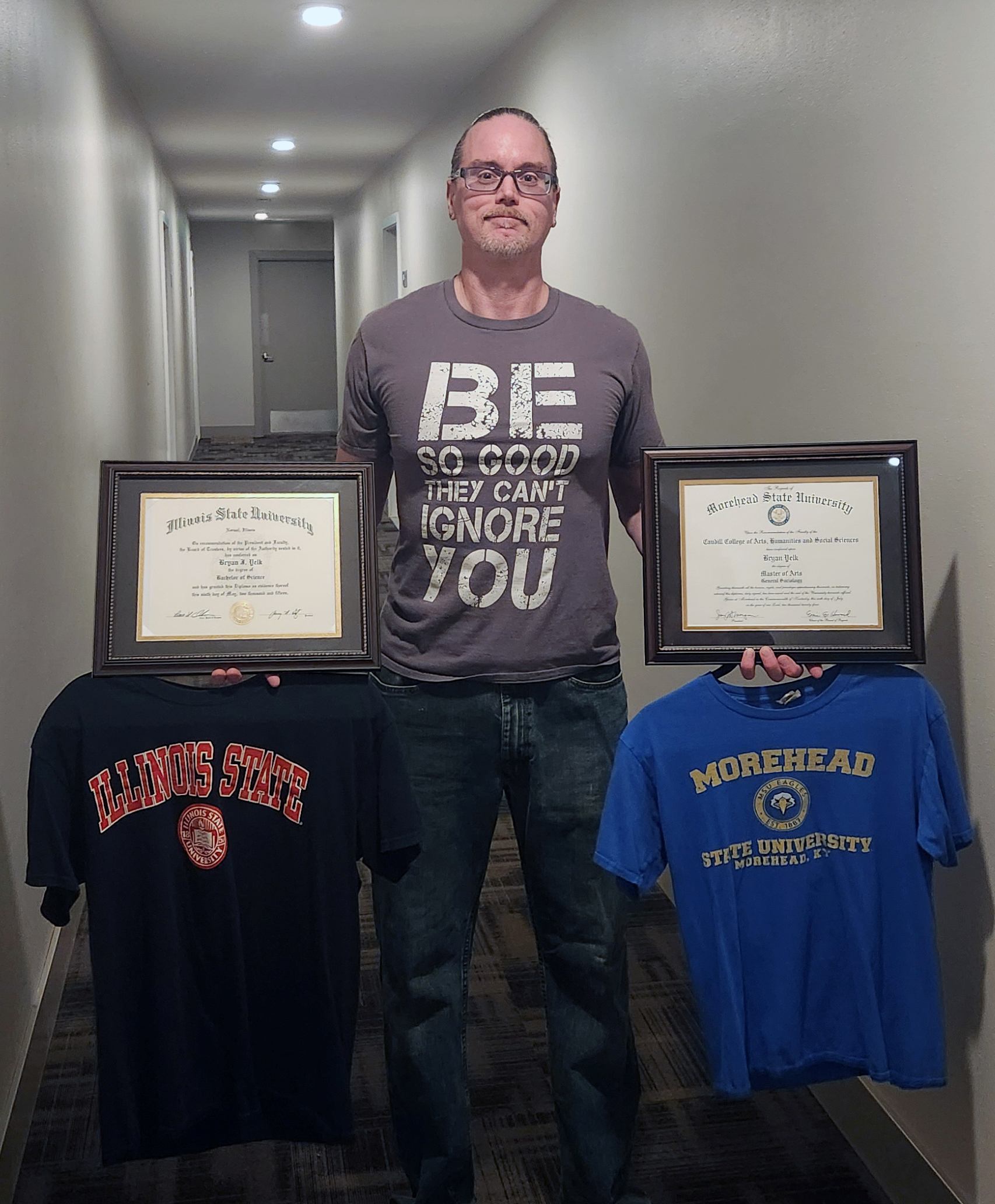 A man holding 2 certificates