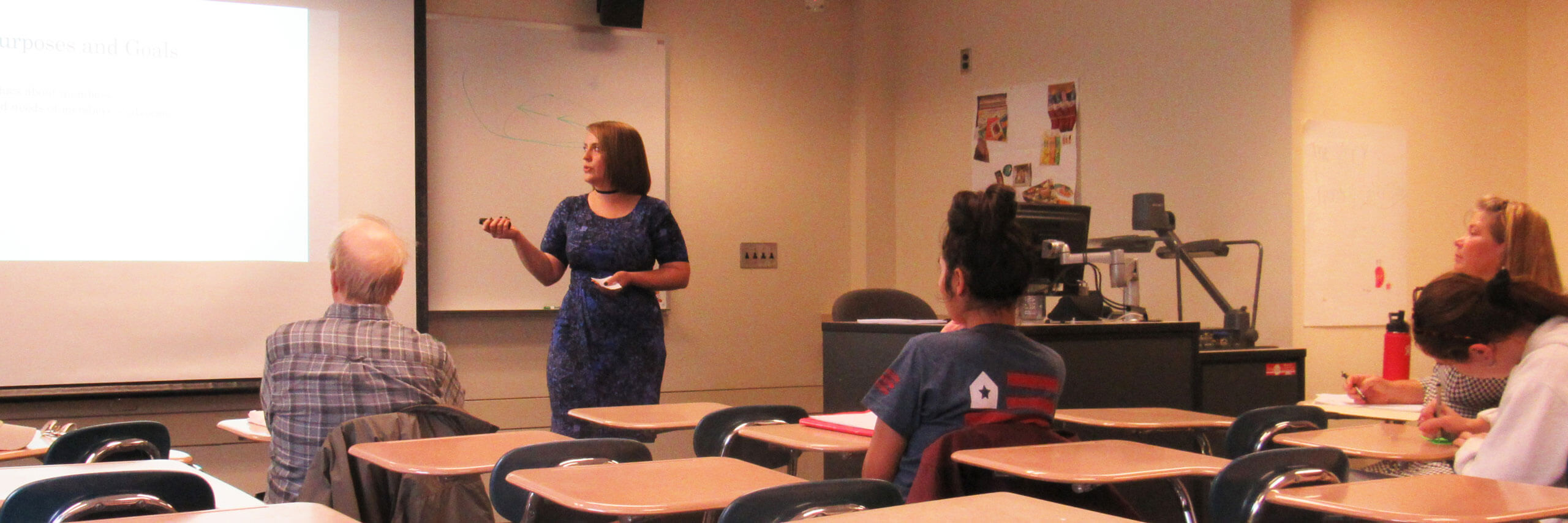 A student gives a presentations to a classroom of spectators.