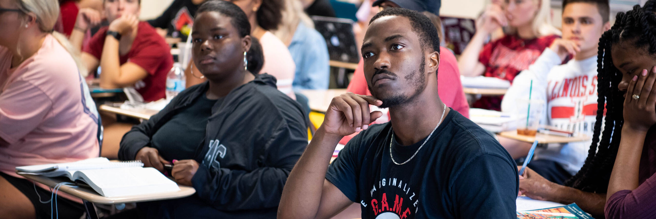 Students in a classroom look attentively toward the lecturer.